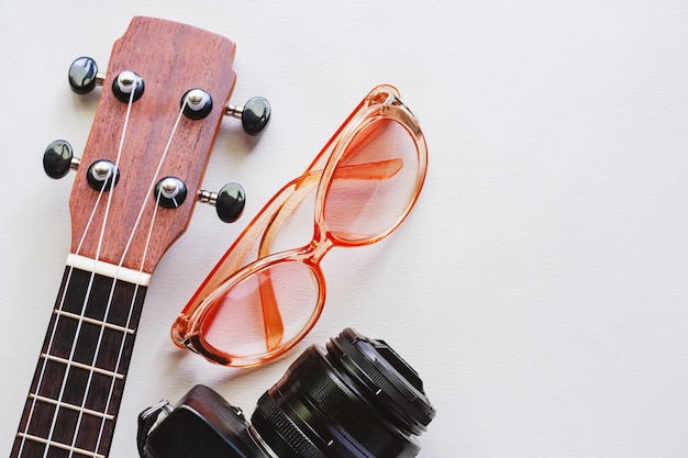 Ukelele met zonnebril en camera op witte achtergrond voor reismateriaal