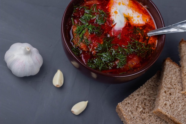 Foto borscht ucraino con panna acida, aglio e pane