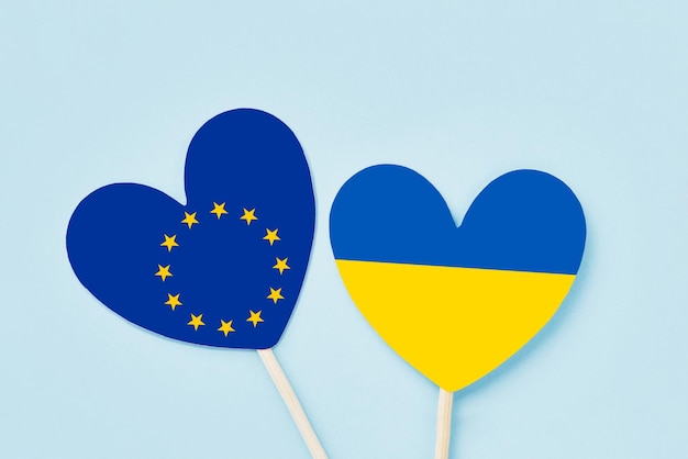 Ukraine and european flag hearts on a light blue backdrop flat lay copy space