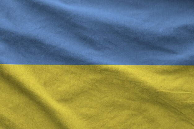 ukraine flag depicted on folded wavy fabric of old cloth