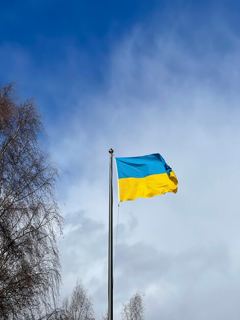 Photo ukraine flag large national symbol fluttering in blue sky