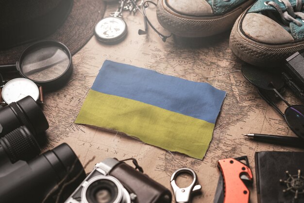 Ukraine Flag Between Traveler's Accessories on Old Vintage Map. Tourist Destination Concept.