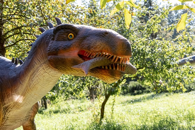 Ukraine, Khmelnitsky, October 2021. Model of a baryonyx dinosaur with fish in his mouth in the park in sunny weather close up