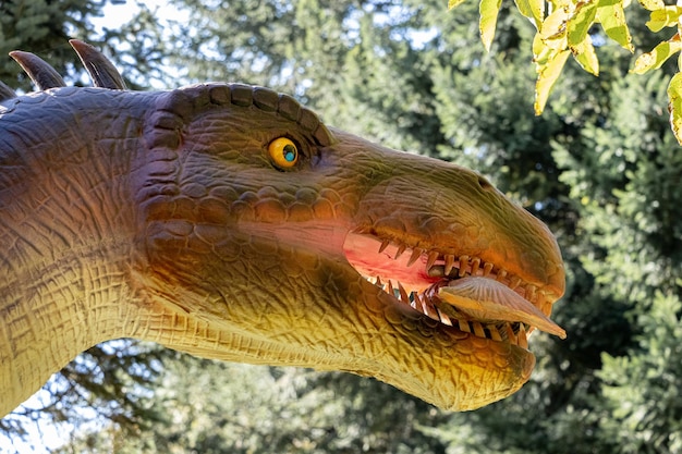 Ukraine, Khmelnitsky, October 2021. Model of a baryonyx dinosaur with fish in his mouth in the park in sunny weather close up