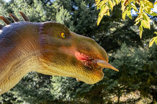 Ukraine, Khmelnitsky, October 2021. Model of a baryonyx dinosaur with fish in his mouth in the park in sunny weather close up