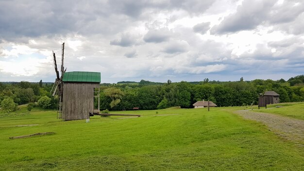 Ukraine, Kiev - June 11, 2020. Old Ukrainian wooden windmills of the XIX century. Summer outdoor landscape. Open-air museum of folk architecture and life, Pirogovo, Ukraine. Tourism and travel.