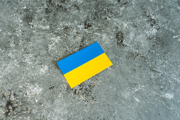 Ukraine national flag on gray concrete cement surface background Place for text War in Ukraine