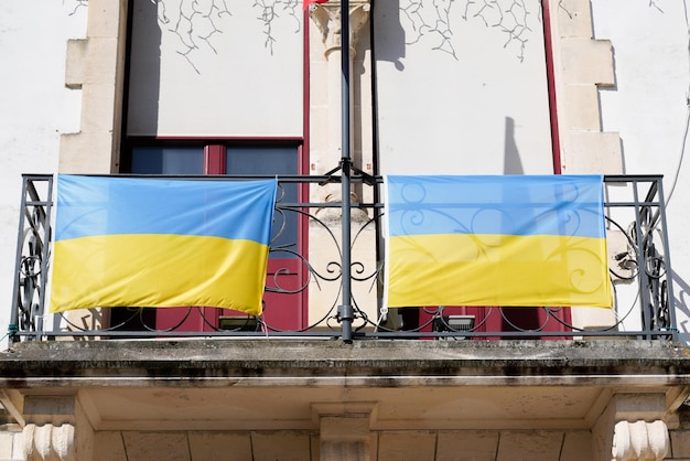 Ukraine national flag state flutters yellow blue on balcony of residential building