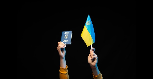 Ukraine national flag on a stick and state biometric passport in hands Symbol of Ukrainian statehood Copy space