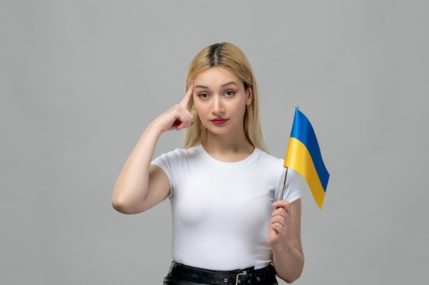 Ukraine russian conflict blonde cute girl with red lipstick and ukrainian flag holding temples