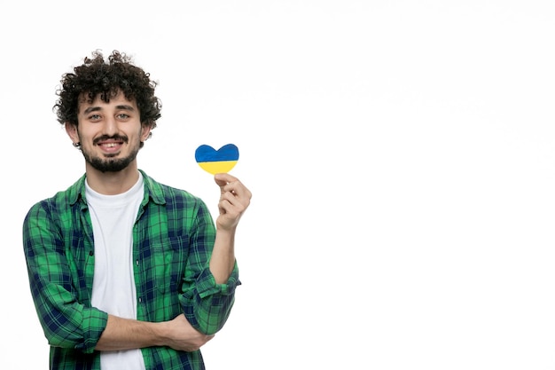 Ukraine russian conflict cute young guy in green shirt holding ukrainian heart holding waist