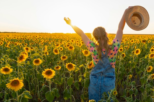 Ukraine. Summer evening. Girl with a hat in a field with sunflowers