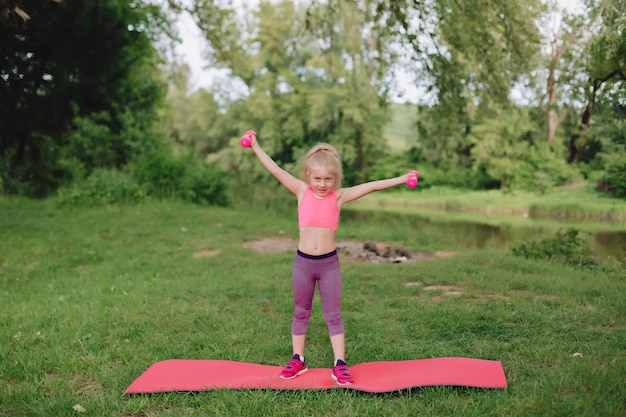 Ukrainian beautiful 7 year old girl with white hair like an angel is engaged in fitness