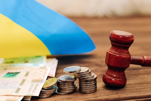 Ukrainian blue yellow flag with judge's gavel and hryvnias on a wooden background