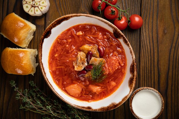 Ukrainian borsch with donuts, tomatoes and garlic