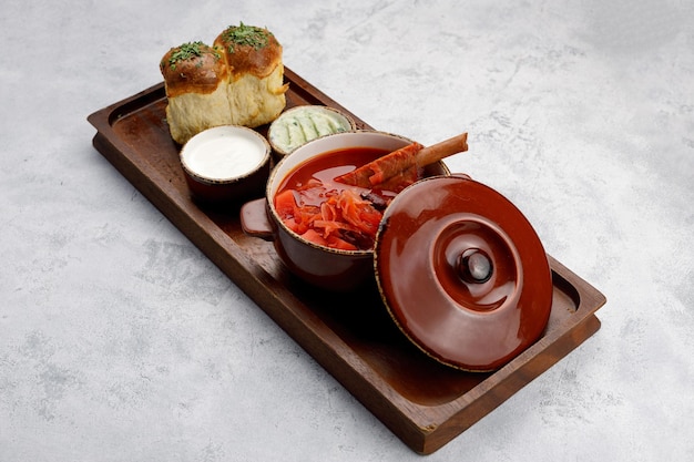 Ukrainian borscht with sour cream on a wooden board