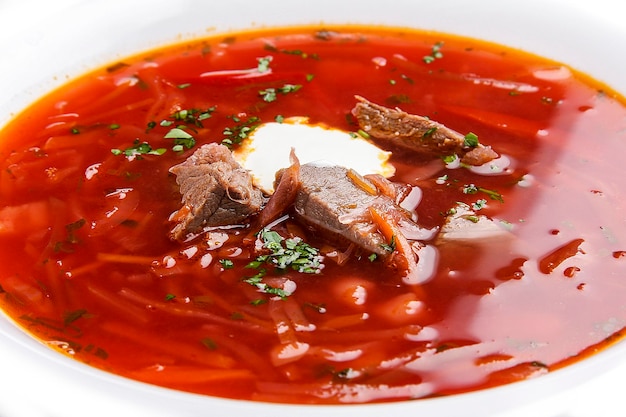 Ukrainian borscht with veal on a white background Traditional dish