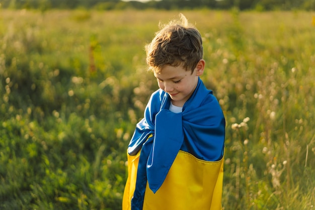 Украинский мальчик в белой футболке с желтым и синим флагом Украины в поле