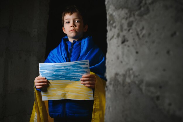 ウクライナの泣いている少年は、ウクライナに対するロシアのウクライナ戦争の描かれた旗を持っていますウクライナの泣いている少年は、メッセージでウクライナの子供との戦争を停止するように求めます戦争を停止します