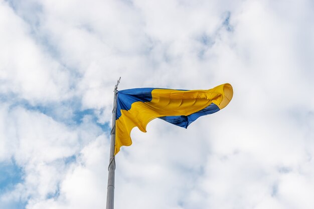 Ukrainian flag waving in the wind against the sky.