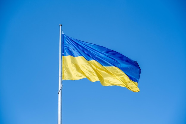 Ukrainian flag in the wind on blue sky background large national yellow blue flag of ukraine big