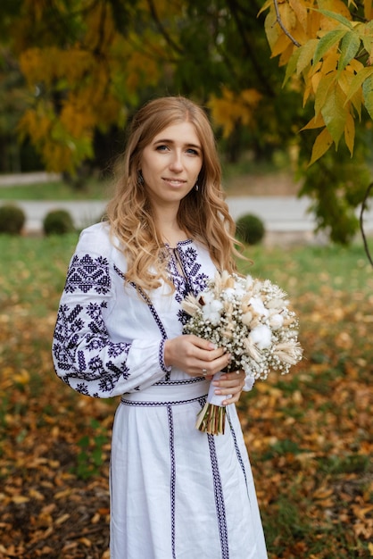 Ukrainian girl bride in a national dress with a blue pattern and a wedding bouquet