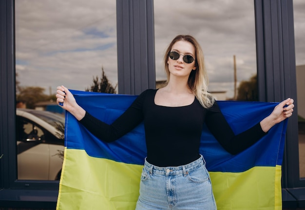 우크라이나 국기를 든 우크라이나 소녀 우크라이나에 대한 지원 애국적인 옷을 입은 소녀 우크라이나의 전쟁 전쟁 중지 우크라이나 여성이 손에 조국의 민달팽이를 쥐고 있습니다