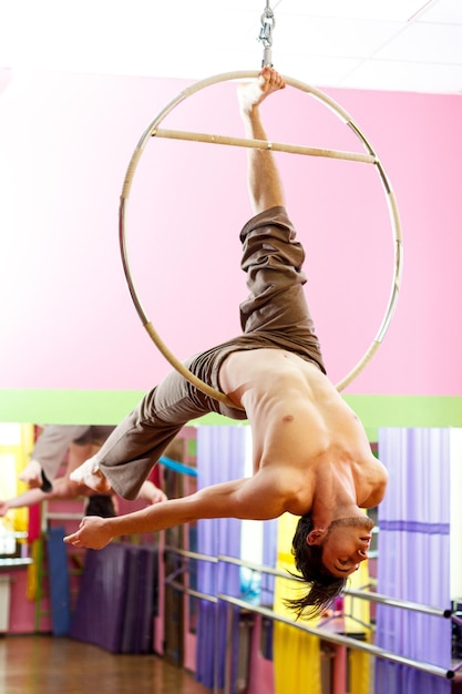 Ukrainian gymnast doing gymnastics with aerial hoop or aerial hoop in the fitness room
