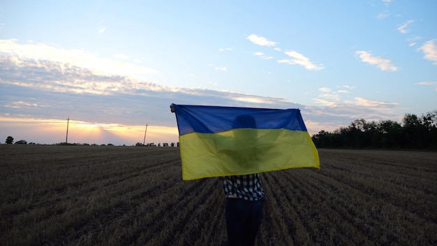 해가 뜨면 보리 들판 에서 국가적 인 파란색 노란색  ⁇ 발 을 들고  ⁇ 고 있는 우크라이나 여성