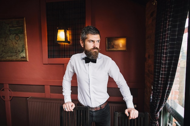 Ukrainian man looks out the window at a cozy pub in the city\
center