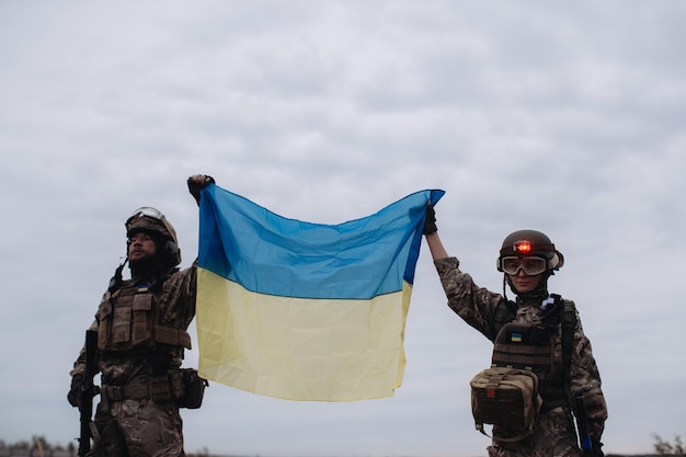 Ukrainian military holds the flag of Ukraine The concept of victory The war Ukraine and Russia