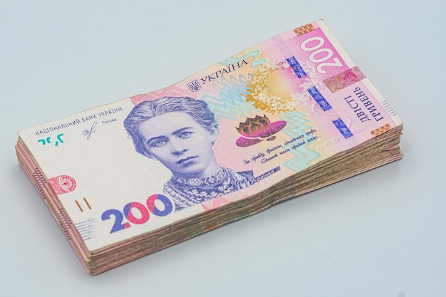 ウクライナ・フリヴニャ・パック (Ukrainian hryvnia pack) はウクライナの国通貨で白い背景の上部の画像ウク라이나の金 (Ukraine's money) 200フリヴィニャ・スタック (200 hryvnia stack) ユクライナの金融給与年金寄付税金などを表しています