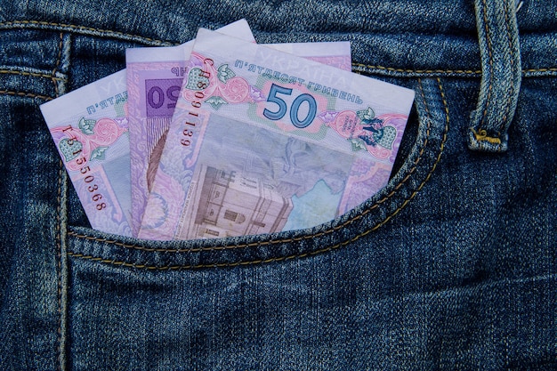 Ukrainian money in a pocket of blue jeans