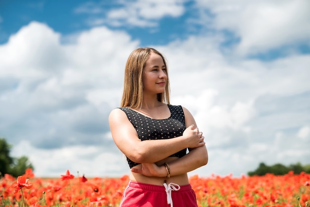 Ukrainian pretty girl enjoying flowers in countryside. Summer time