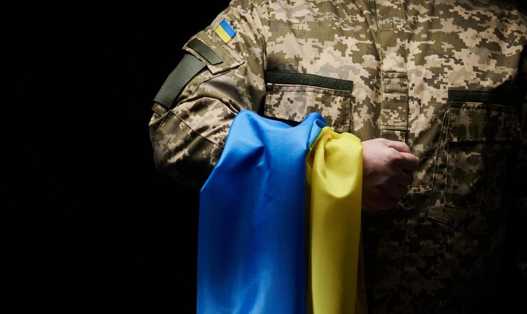 Украинский солдат держит флаг независимого государства Украина Стойкость и мужество народа в борьбе с оккупантами Несломленный дух нации Символ независимости
