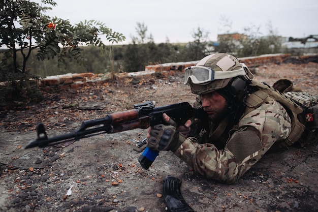 The Ukrainian Soldier in war with weapons in his hands aiming at the enemy