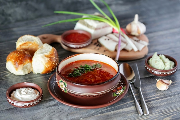 Ukrainian soup bortchsh. Traditional ukrainian cuisine. Salo wigh garlic onion and bread rolls. Sour cream a  sauces.