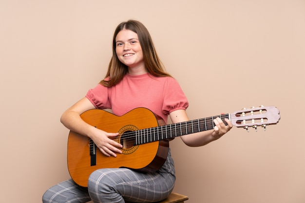 Ukrainian teenager girl with guitar over isolated