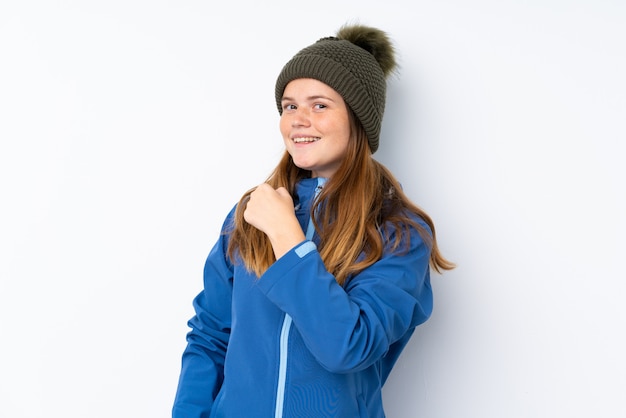 Ukrainian teenager girl with winter hat over isolated  celebrating a victory