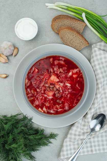 Ukrainian vegetarian borscht with beans on a gray background