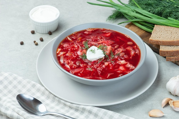 Ukrainian vegetarian borscht with beans on a gray background