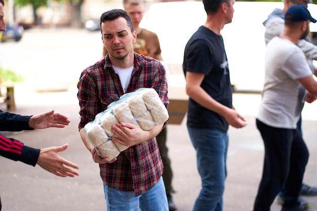 ウクライナ人ボランティアが人道支援物資を箱から降ろす