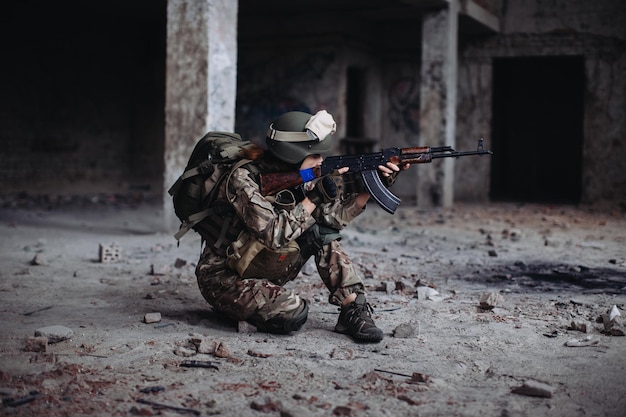 Ukrainian woman soldier with a weapon in his hands in a\
destroyed building war between ukraine and russia