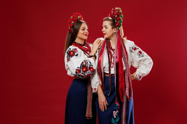 Ukrainian women in traditional ethnic clothing and floral red wreath on viva magenta studio background National embroidered dress call vyshyvanka Pray for Ukraine