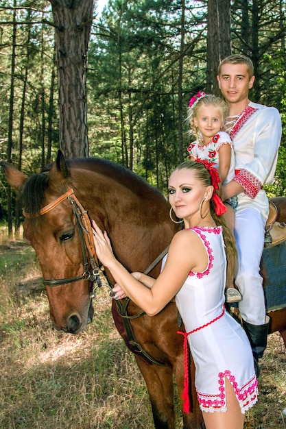 Ukrainians mom and dad daughter ride in the woods on horseback