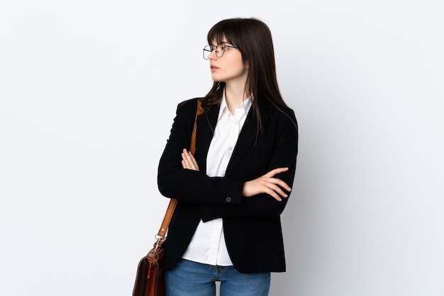 Ukranian business woman isolated on white wall looking side