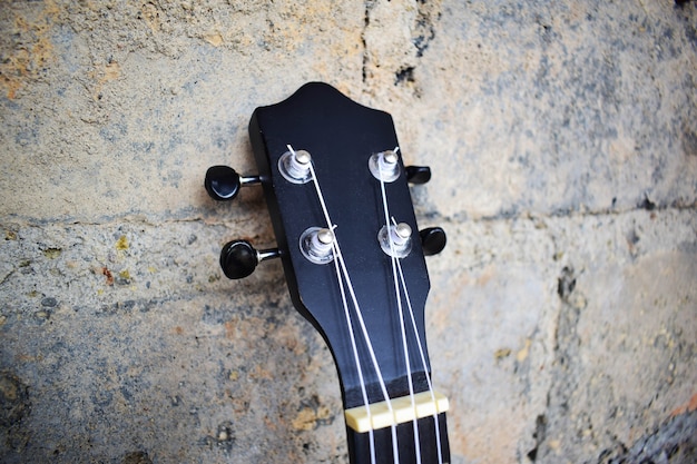 Foto chitarra ukulele sul muro