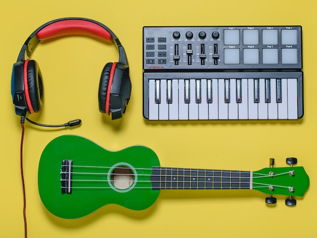 Foto ukulele e microfono blu metallico su fondo giallo. la vista dall'alto.