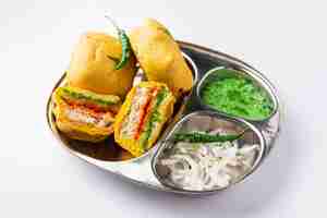 Photo ulta vada pav is made with a spicy potato stuffed bun called pav inside vada inside out wada pao