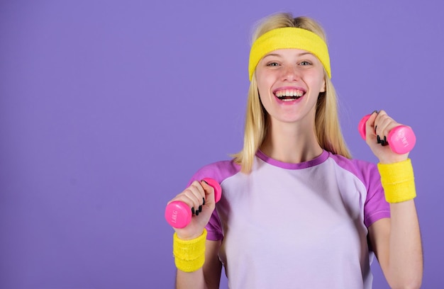 Ultieme training van het bovenlichaam voor vrouwen Meisje houdt halters dragen heldere polsbandjes Vintage sportconcept Vrouw oefenen met halters Eenvoudige oefeningen met halters Training met halters